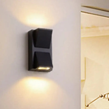 Black modern minimalist triangle aluminum flush wall lamp with two angled light panels emitting warm corridor light
