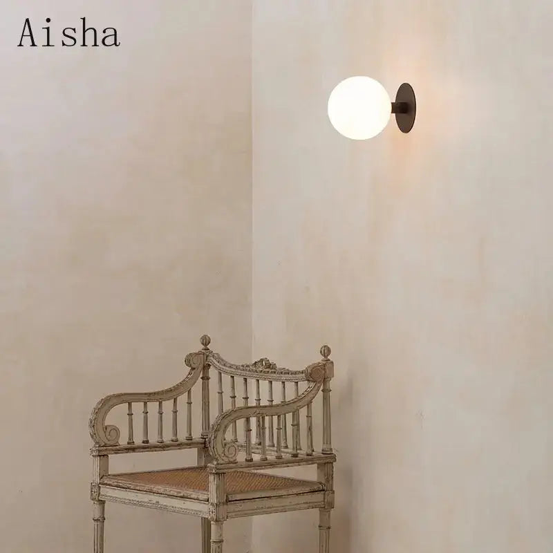 Minimalist black wall lamp with frosted white glass globe and matte metal base lighting fixture by decorbites gold