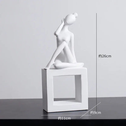 White ceramic figurine of a seated woman on a square base in minimalist black and white decorbites abstract resin sculpture