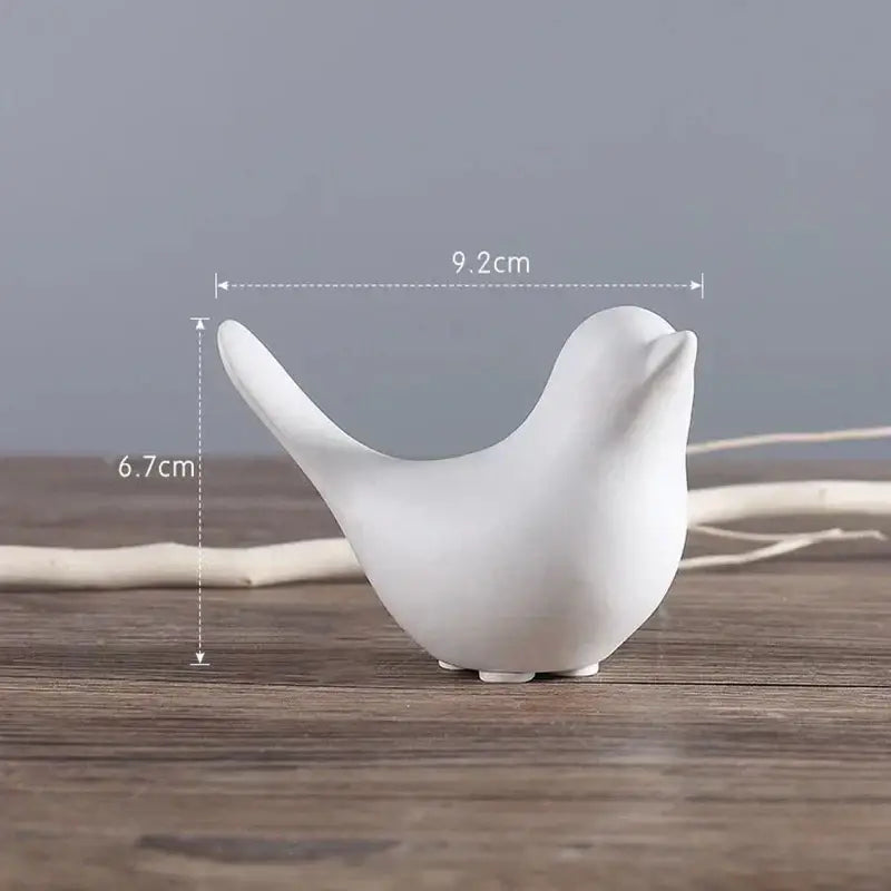 White ceramic bird figurine with smooth minimalist design and rounded features in a black and white figurine set
