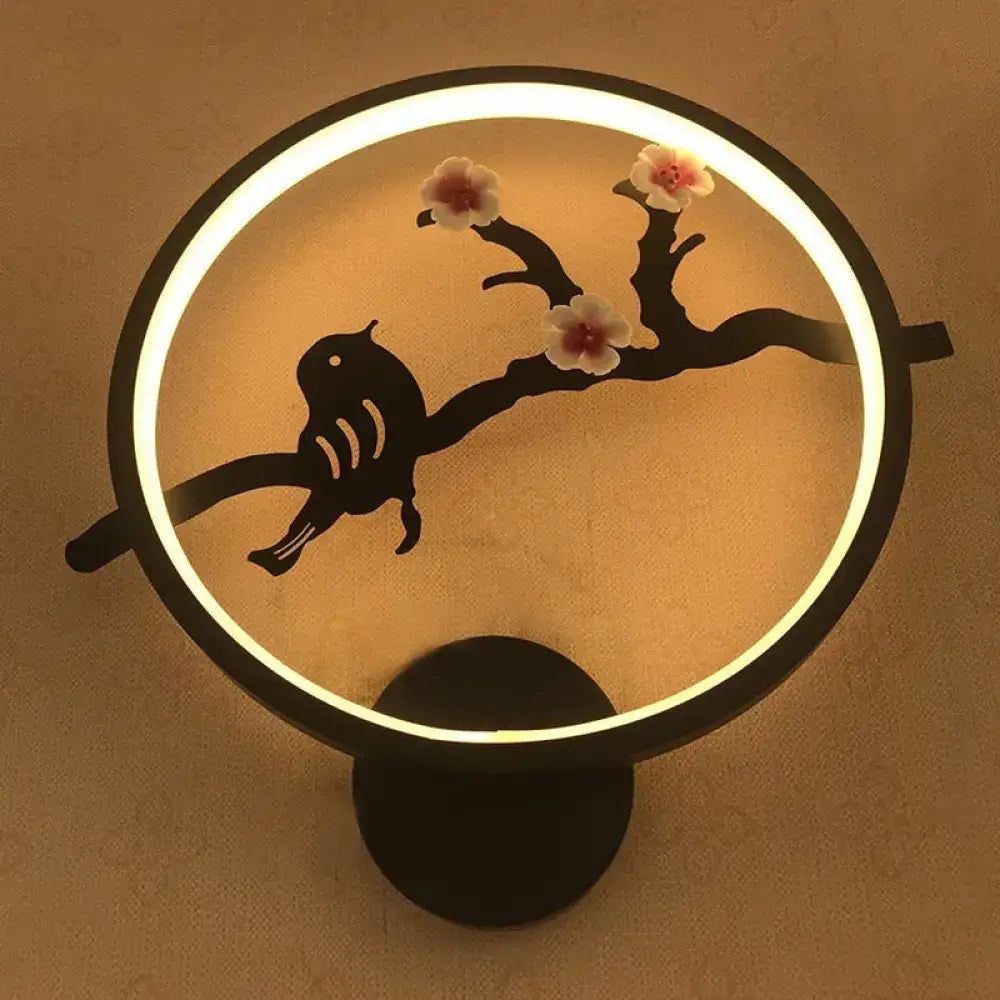 Minimalist black and white circular led wall sconce with glowing bird silhouette and pink blossoms for living room