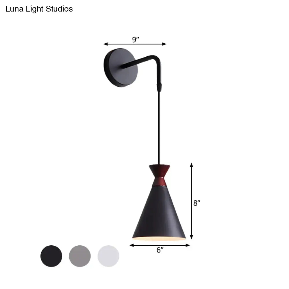 Minimalist black matte iron conical wall light with red accent on adjustable curved arm for bedroom use