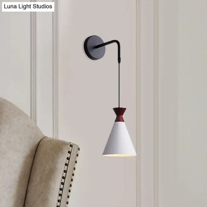 A sleek black iron conical wall light with white shade and burgundy accent minimalist wall sconce for bedroom