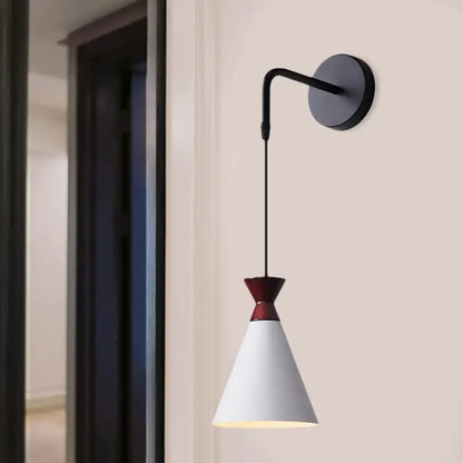 Minimalist black and white iron conical wall light with a sleek curved arm and burgundy accent for bedroom use