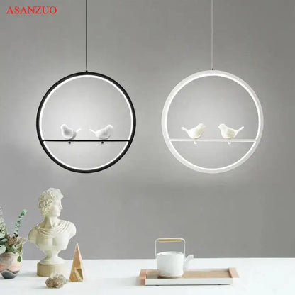 Two minimalist circular pendant lights with black and white frames featuring white ceramic birds decorbites bird chandelier