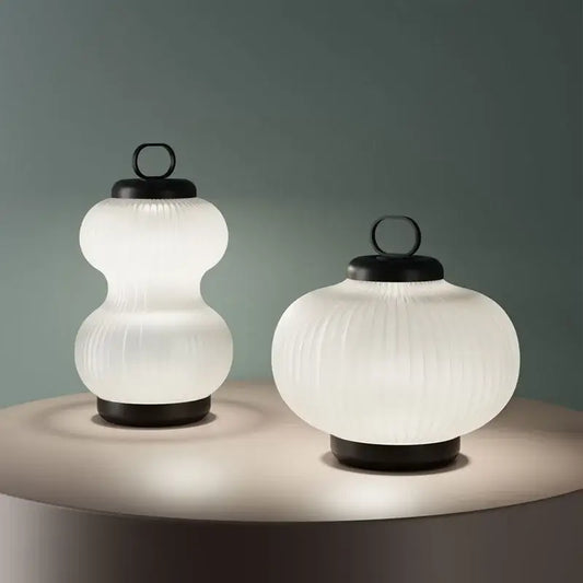 Two illuminated minimalist black and white glass chandelier bedroom lantern lights with frosted white glass and black metal base