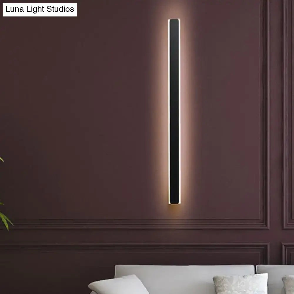 Minimalist black rectangular wall lamp with sleek design and warm ambient lighting for bedroom use
