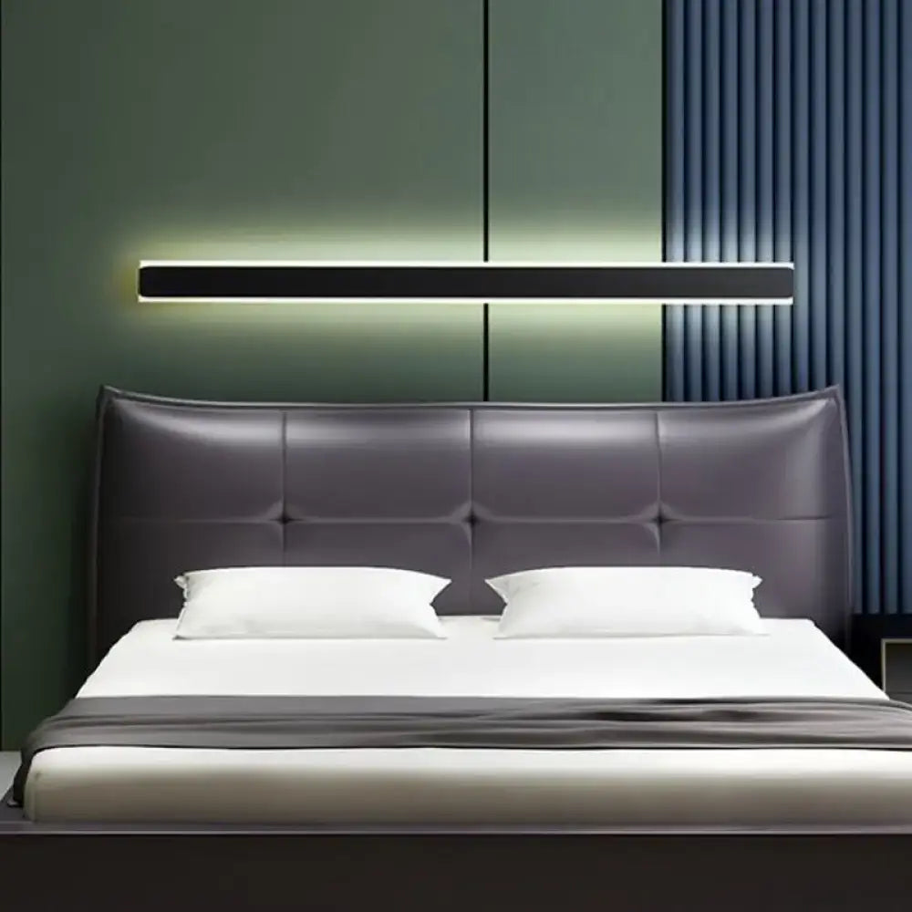 Modern dark gray tufted leather headboard with minimalist design and black and white led wall lamp bedroom sconce