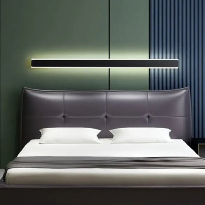 Modern dark gray tufted leather headboard with minimalist design and black and white led wall lamp bedroom sconce