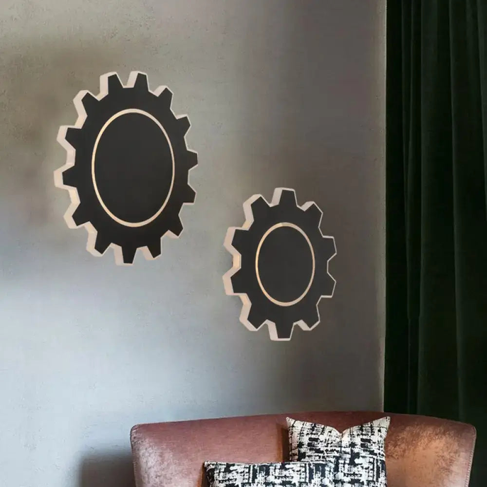 Minimalist black and cream gear-shaped wall sconce with warm white light for bedroom use in black white design