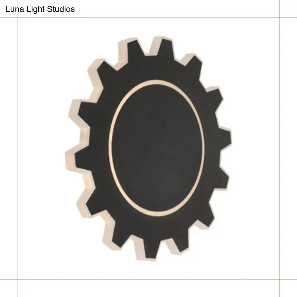 Black gear-shaped wall mirror with gold-toned inner rim complements minimalist black white led wall sconce with warm white light