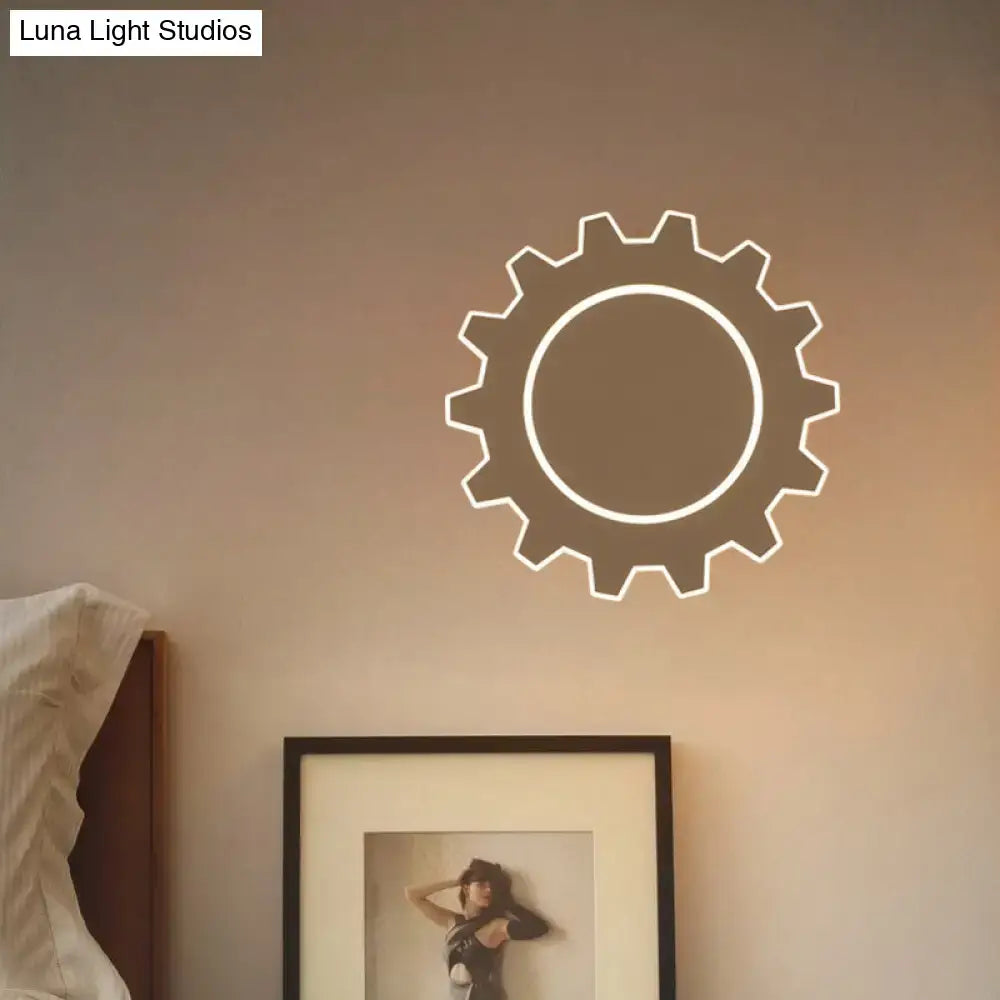 Minimalist black white led wall sconce with white neon gear design casting soft warm white light on beige wall
