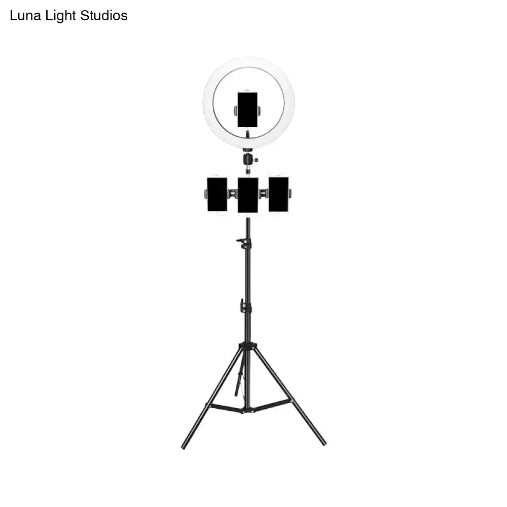 Minimalist black and white mobile phone holder with ring light mounted on tripod stand for bedroom use