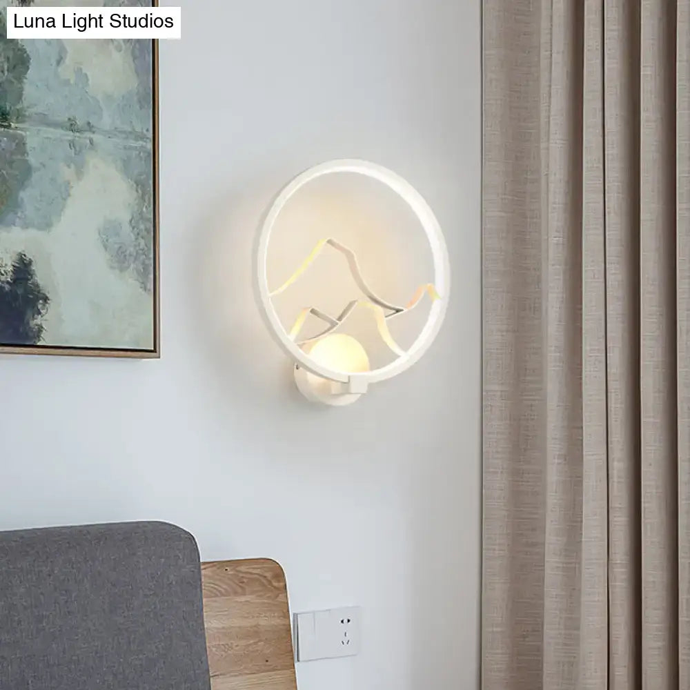 Modern white circular acrylic ring wall lamp with minimalist black mountain silhouette design for bedroom use