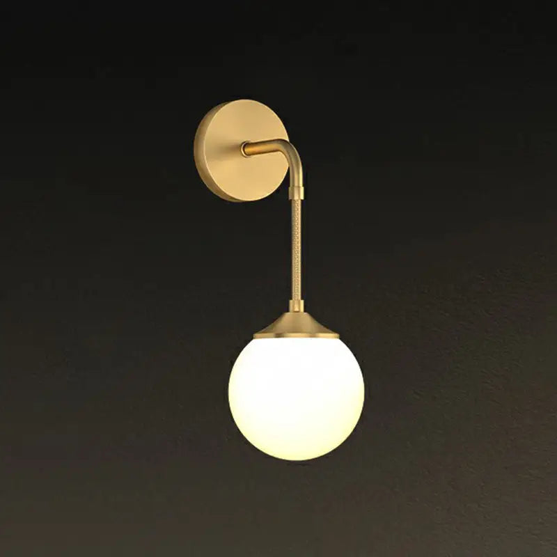 Minimalist gold-toned brass led wall lamp with curved arm and frosted glass globe for dining room lighting