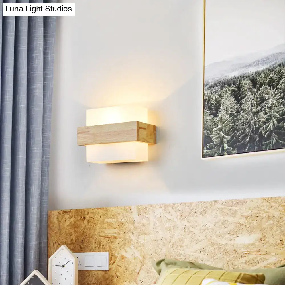 Minimalist brass and glass geometric wall sconce with modern wooden layered rectangular design and warm glowing light