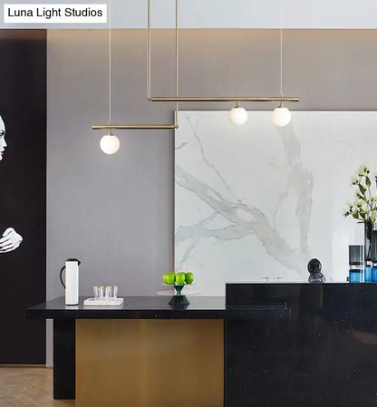 Minimalist brass ceiling light with slender gold rods and white globe glass bulbs for kitchen island lighting