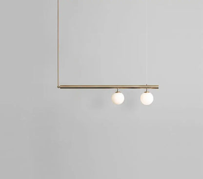 Minimalist brass ceiling light with two white globe glass bulbs designed for kitchen island lighting