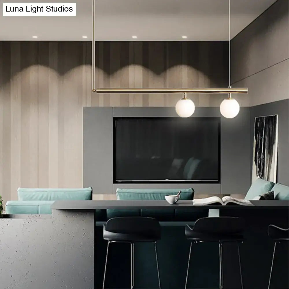 Minimalist brass ceiling light with white glass globe bulbs designed for kitchen island lighting