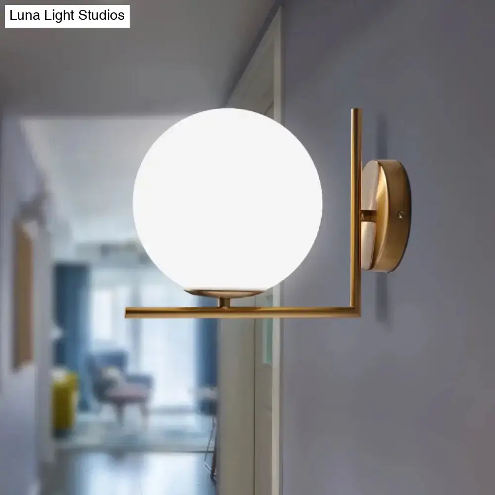 Minimalist brass angle arm wall sconce with gold-tone finish and opaline glass globe for e12 e14 bulbs