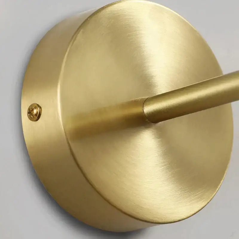 Minimalist brass and black iron wall lamp with circular base and cylindrical arm for bedroom decorbites iron wall lamp