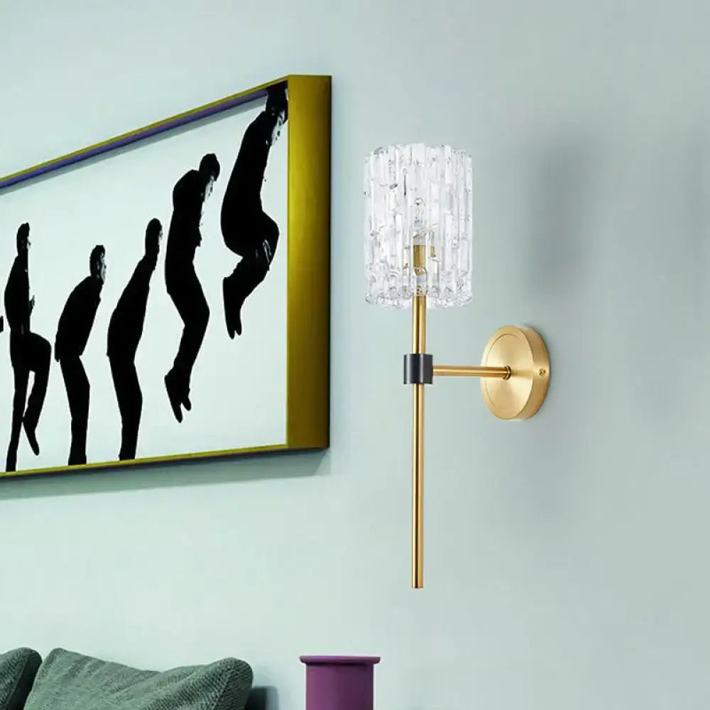 Gold-toned minimalist brass crystal cylindrical wall sconce for living room featuring a clear cylindrical crystal shade