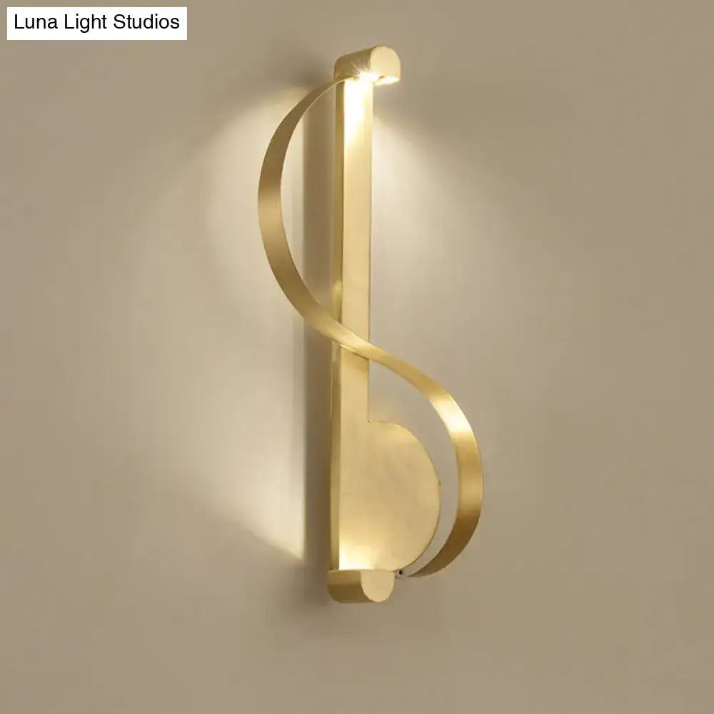 Gold-toned minimalist brass curve led wall mount light with modern abstract musical note design for living room