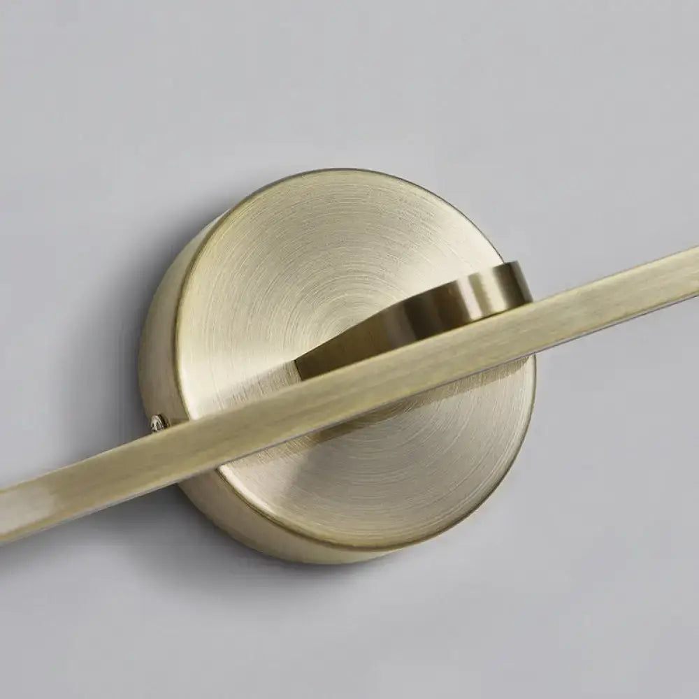 Brass-finished minimalist elliptical wall light with circular base and slender horizontal arm for bathroom sconce fixture