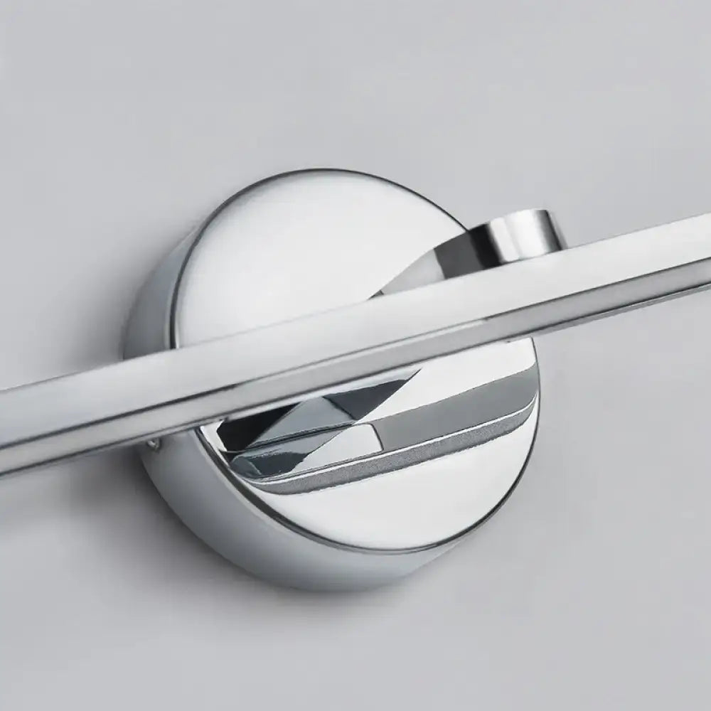 Chrome-finished circular wall-mounted towel rack with sleek modern design complementing minimalist brass elliptical wall light