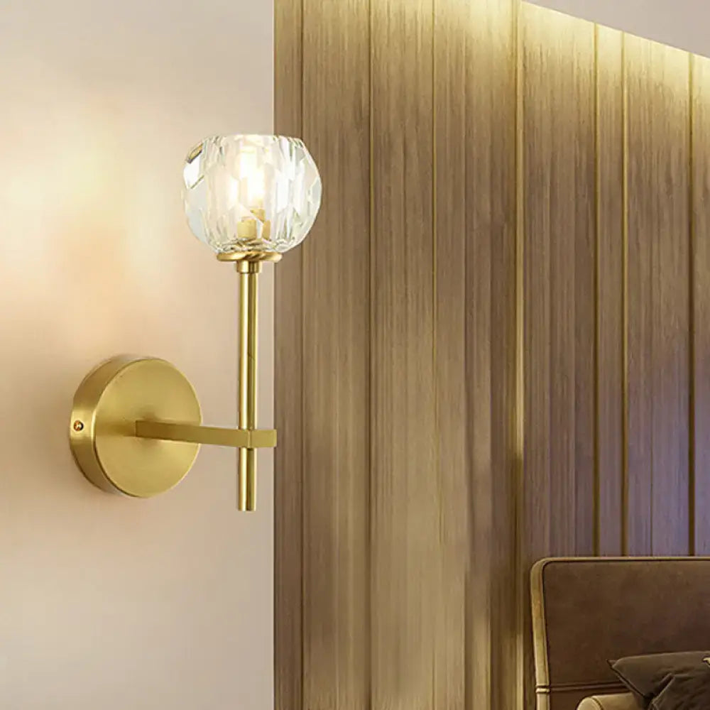 Minimalist gold-toned brass wall sconce with faceted crystal globe shade, direct wired, available in two sizes for bedroom lighting