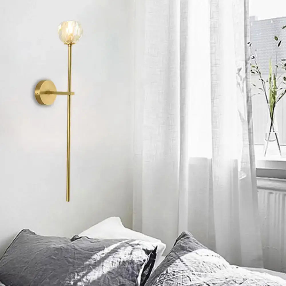 Minimalist brass faceted crystal wall sconce with gold tone direct wired slender stem and frosted glass globe in two sizes