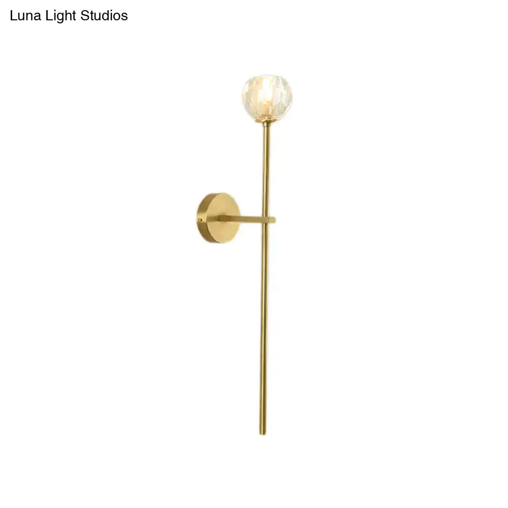 Minimalist brass wall sconce with faceted crystal globe, gold-toned direct wired design available in two sizes