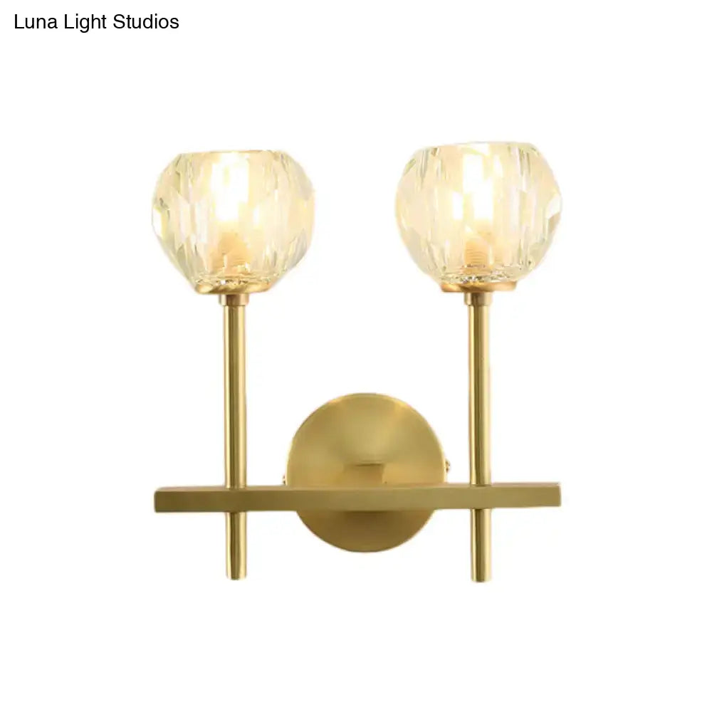 Minimalist gold-toned brass wall sconce with two faceted crystal globe shades in two sizes direct wired for bedroom lighting