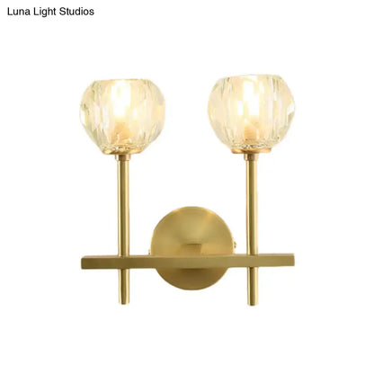 Minimalist gold-toned brass wall sconce with two faceted crystal globe shades in two sizes direct wired for bedroom lighting