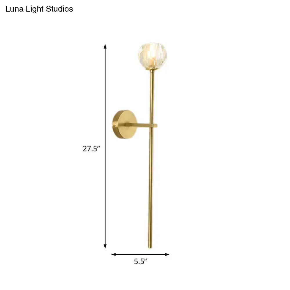 Minimalist brass faceted crystal wall sconce with gold-toned stem and direct wired installation in two sizes