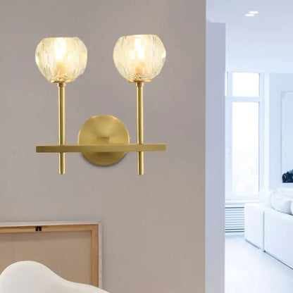 Minimalist brass wall sconce with gold tone and two faceted crystal shades direct wired for bedroom lighting