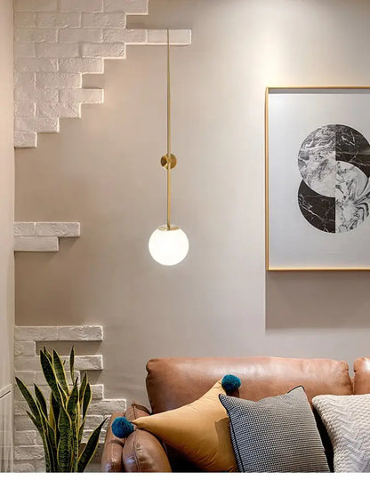 Minimalist brass led wall lights featuring a gold-toned pendant with a frosted globe for bedroom use