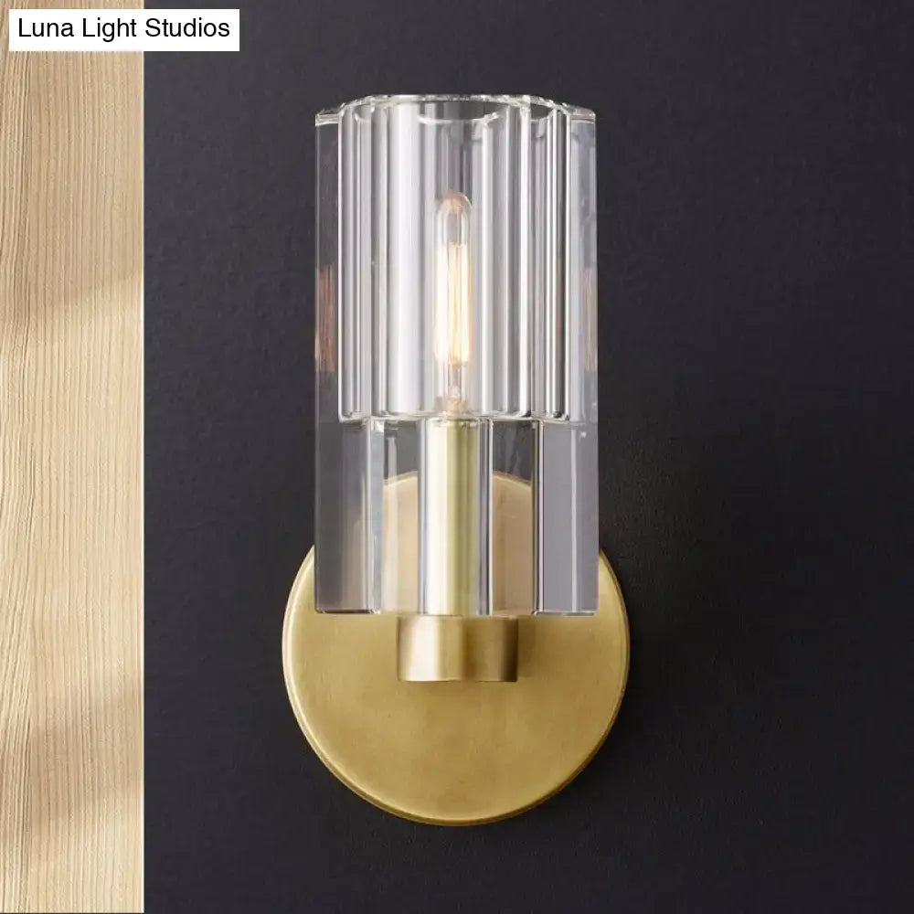 Minimalist brass wall sconce with clear vertically ribbed glass cylinder bulb base for living room lighting