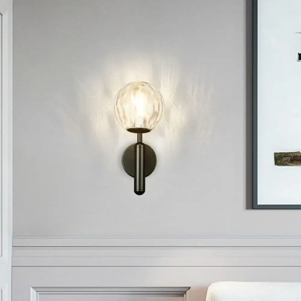 Minimalist wall mount light with textured glass globe and matte black metal base for bedroom lighting