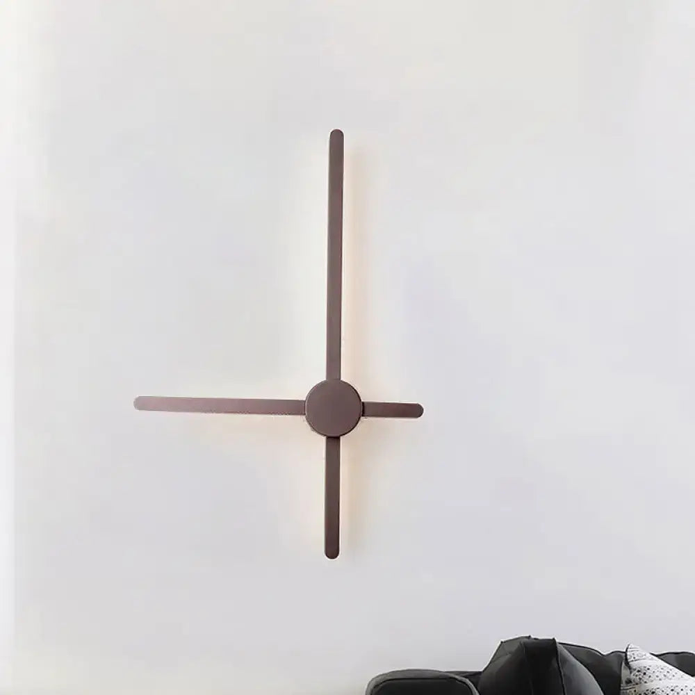 Minimalist sconce wall light with sleek matte bronze arms and a circular base for living room clock lighting