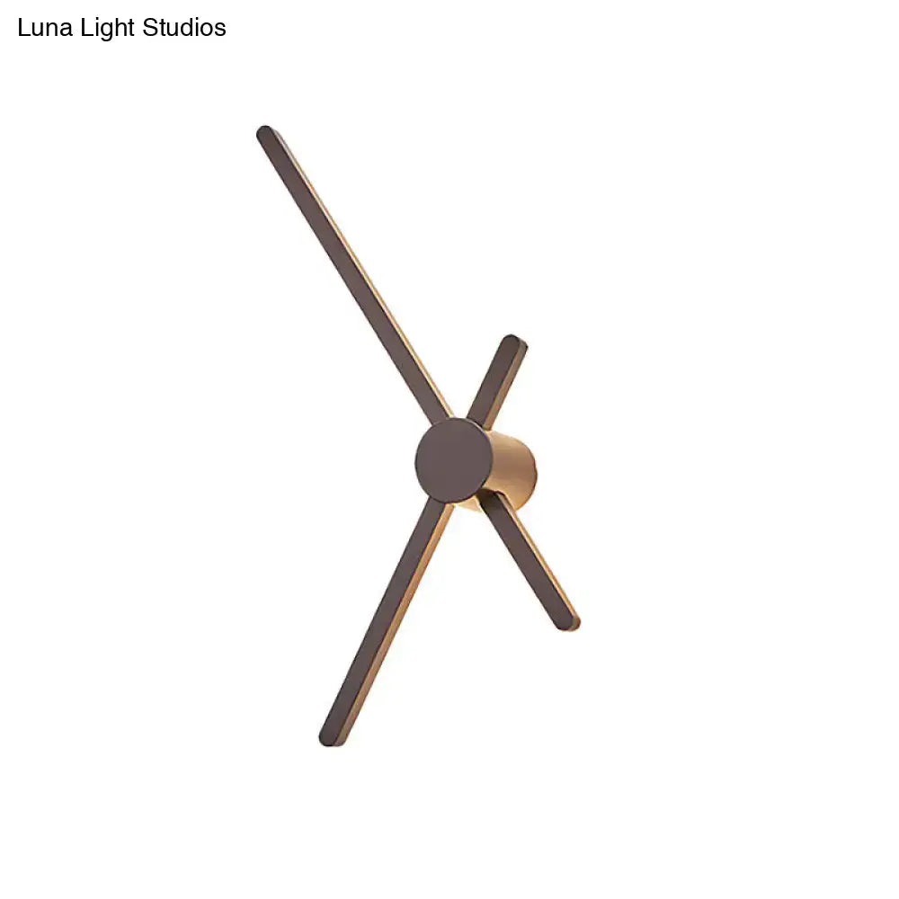 Minimalist brass sconce wall light with slender matte bronze arms and cylindrical base for living room clock lighting