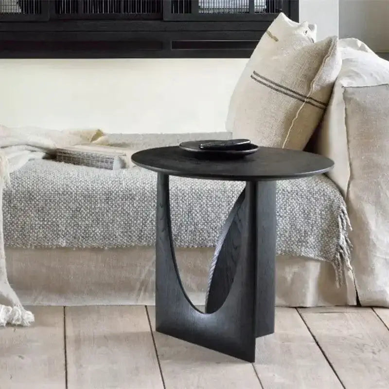 Black minimalist coffee table with a sleek sculpted base and circular walnut wood top for modern living room decorbites circular walnut