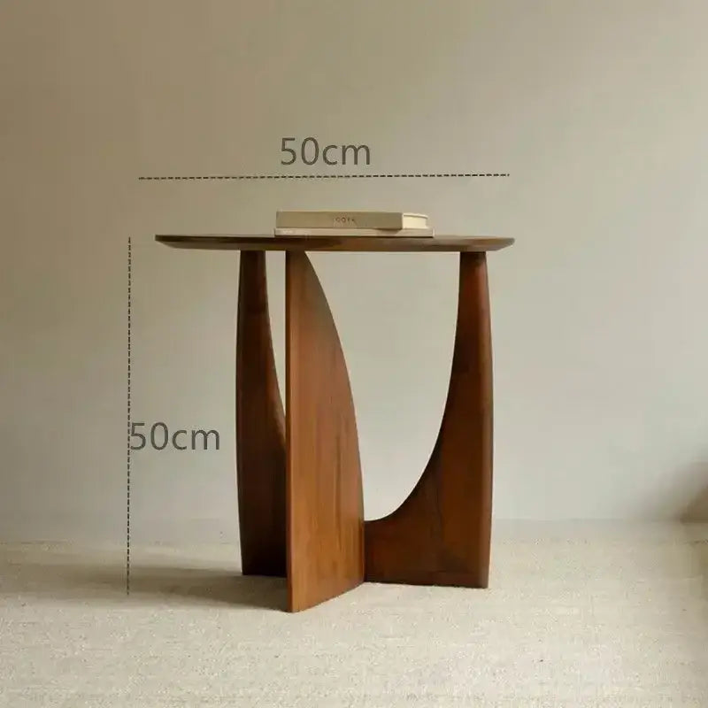 Minimalist circular walnut wood coffee table with warm brown finish and sculpted asymmetrical legs for living room decorbites