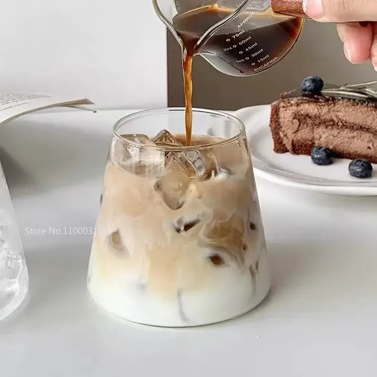 A clear minimalist glass water cup filled with ice and creamy iced coffee for kitchen and dining use