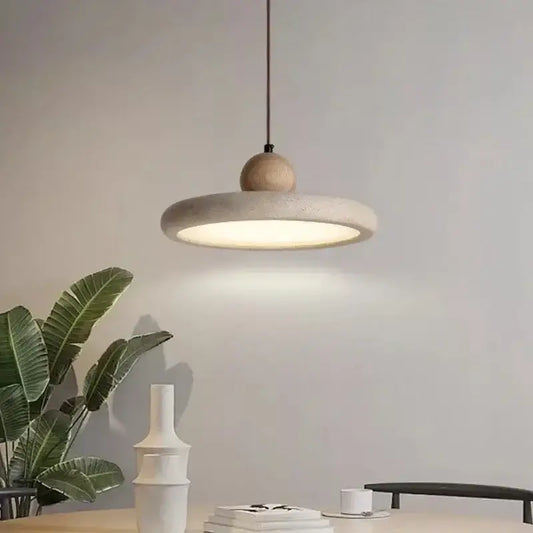 Minimalist concrete and wood pendant light with natural materials creating a welcoming atmosphere in dining room settings