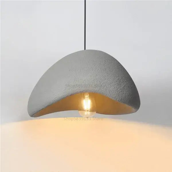 Gray concrete decorbites cobblestone pendant lights featuring a warm exposed bulb for minimalist dining room decor