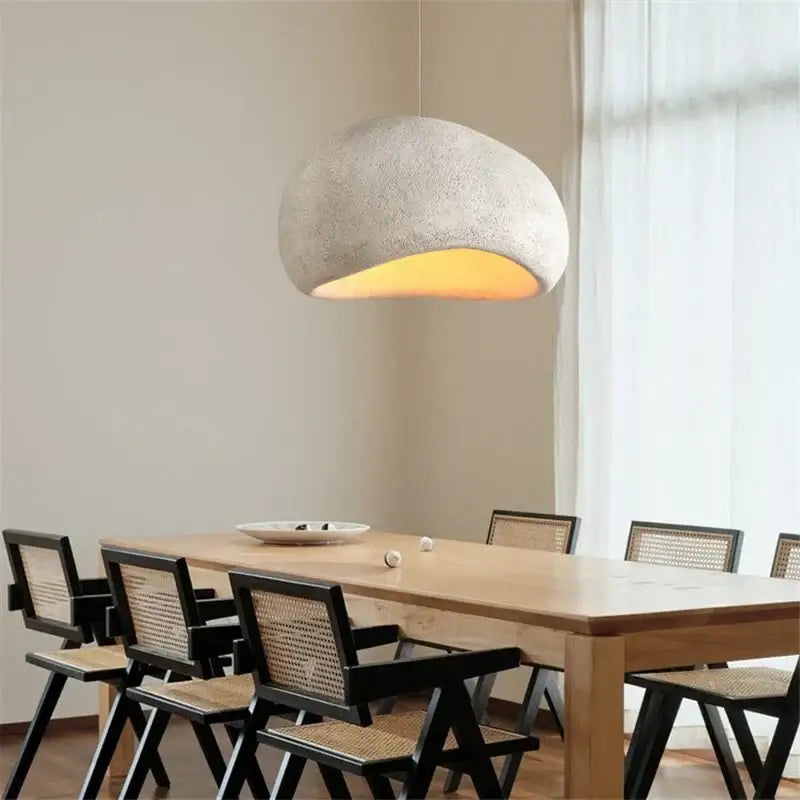 Minimalist light gray concrete decorbites cobblestone pendant lights with warm yellow glow for dining room lighting