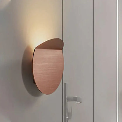 Minimalist copper sconce light with a sleek curved design wall mount featuring an led bulb for bedroom use