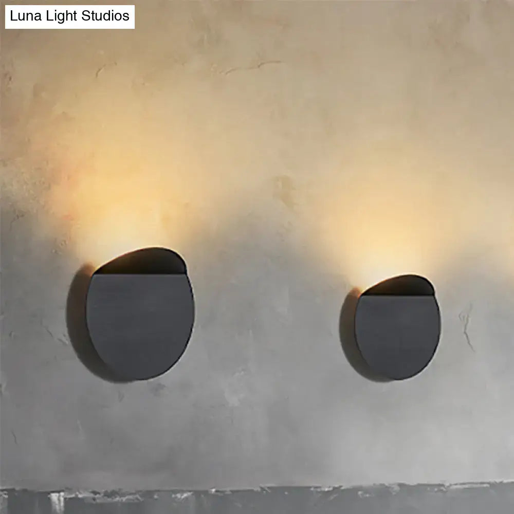 Minimalist copper wall mount sconce light with modern matte black circular design and warm led bulb lighting