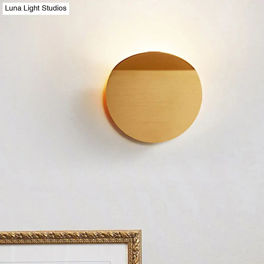 A sleek gold-finished minimalist circular wall mount sconce light with brushed metal surface and led bulb for bedroom use